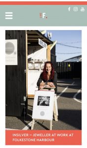 Aimi is standing outside the inSilver hut, leaning on a sign